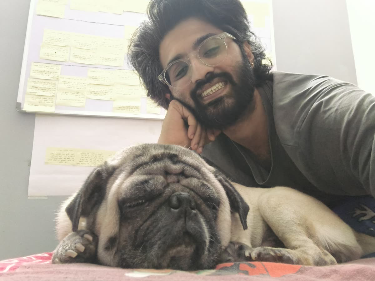 Akash and Brando on a couch by a wall of notes